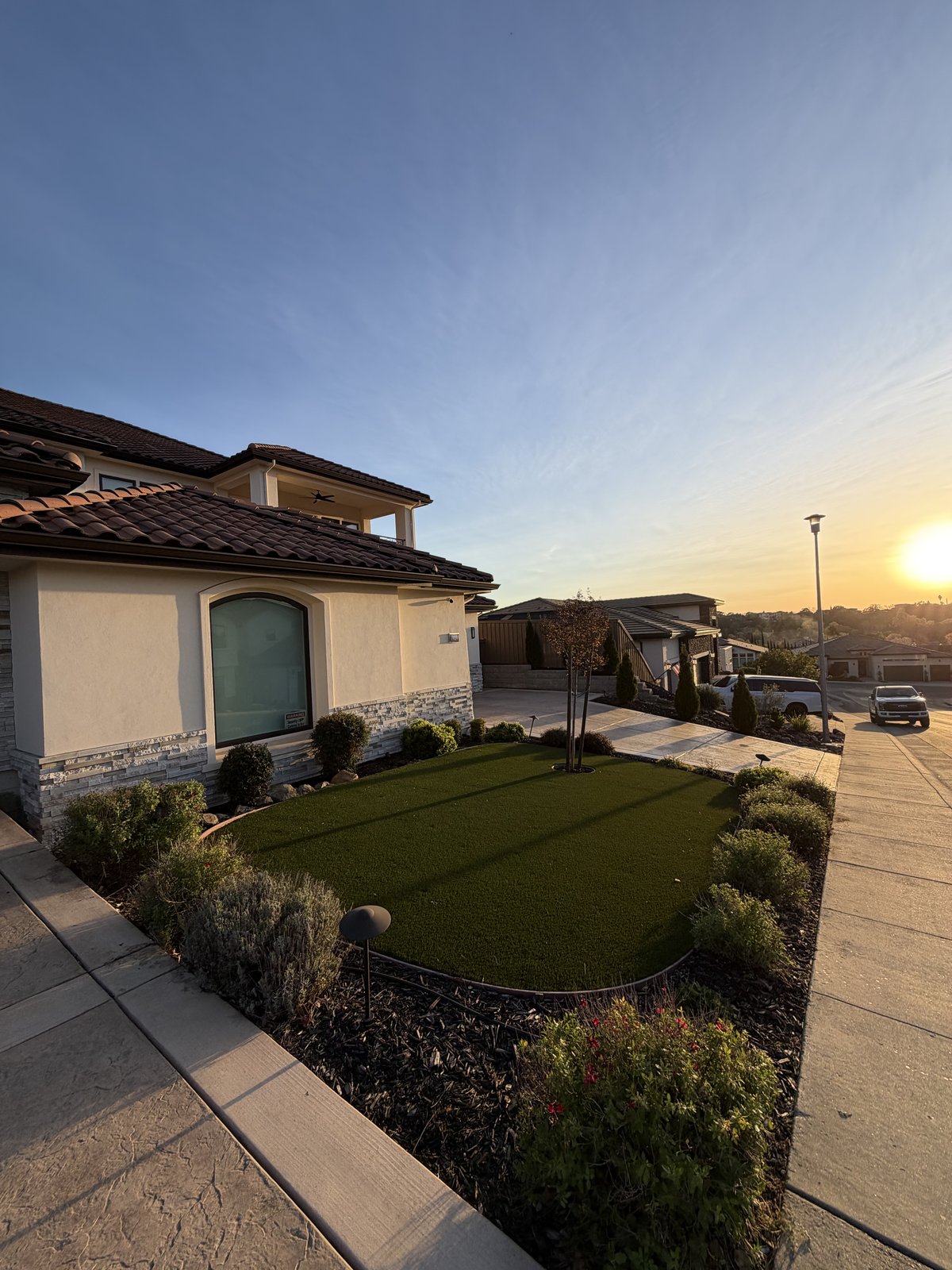 Fresh front-yard turf install with a paver path at sunset in Sacramento